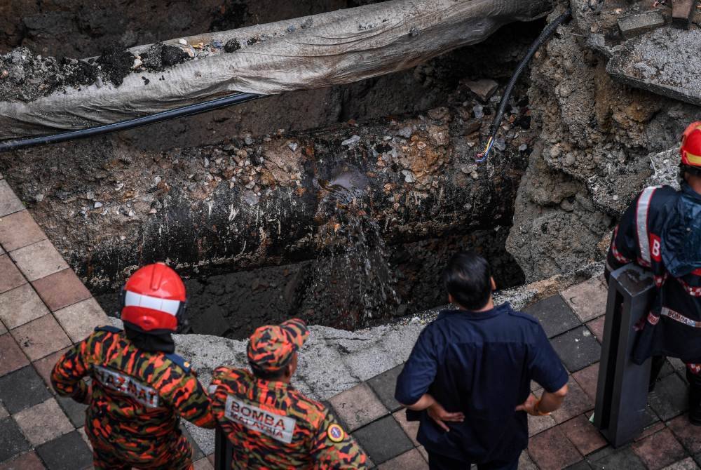 Anggota Jabatan Bomba dan Penyelamat Malaysia serta Angkatan Pertahanan Awam Malaysia kini giat menjalankan kerja-kerja mengeluarkan mangsa yang merupakan seorang pelancong. Foto Bernama