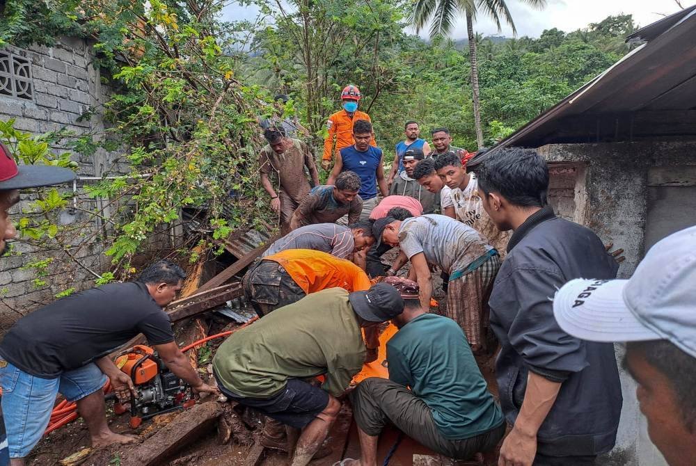 Penyelamat dan penduduk memindahkan mayat mangsa banjir kilat di Rua, Pulau Ternate pada Ahad. Foto EPA