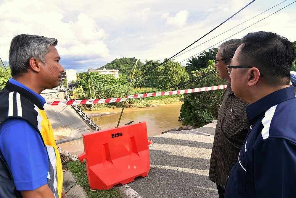 Mohammad Nizar (dua, kanan) ketika meninjau jambatan lama Sungai Slim yang runtuh akibat kejadian kepala air.
Foto Bernama