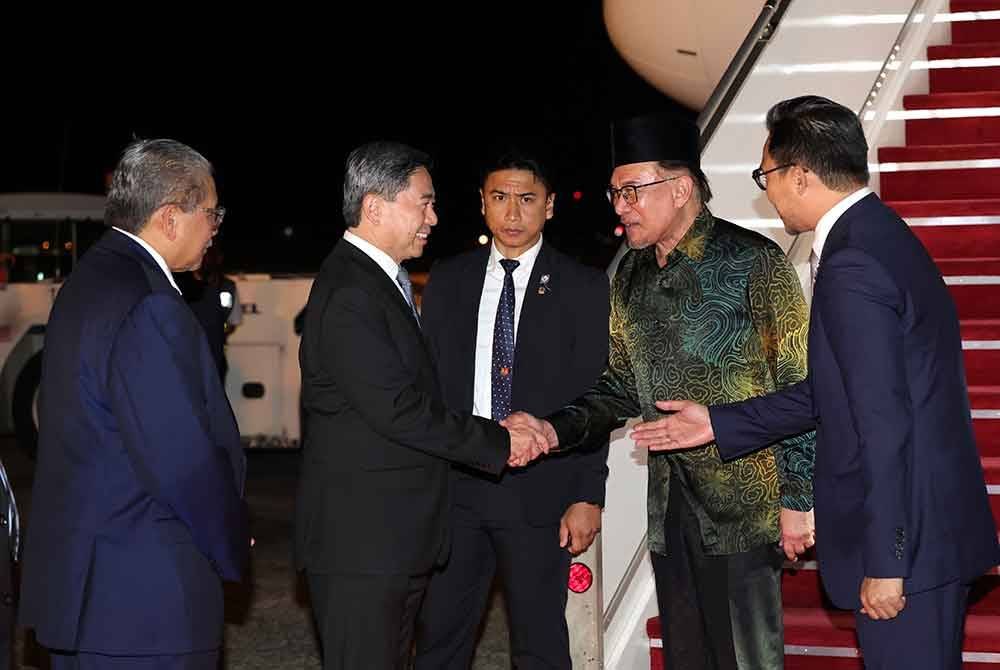 Anwar bersalaman dengan Awang (dua, kiri) dan Erywan (kiri) sebaik tiba di Lapangan Terbang Antarabangsa Brunei Darussalam pada malam Ahad. Foto Bernama