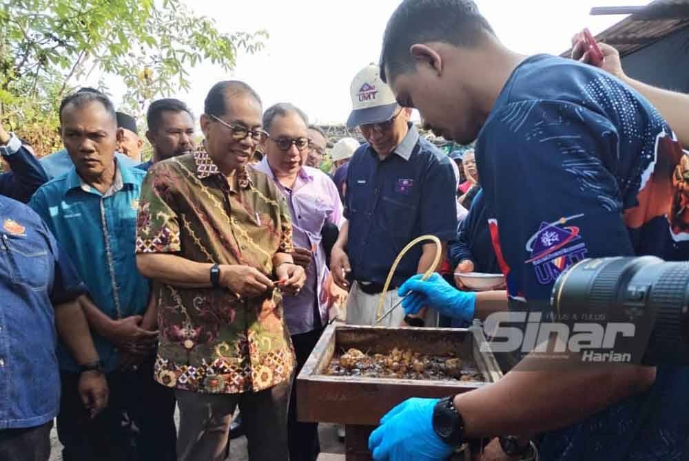 Mohamed Khaled (tiga dari kiri) mencuba keenakan madu kelulut ketika melawat Tapak Projek Pemindahan Ilmu (KTP), Ternakan Kelulut Sedili pada Isnin,