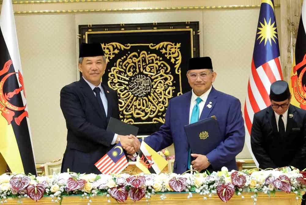 Erywan Pehin (kanan) mewakili negara Brunei, bersama Menteri Luar Malaysia, Datuk Seri Mohamad Hasan, bertukar dokumen selepas menandatangani perjanjian persefahaman dua hala Malaysia-Brunei di Istana Nurul Iman pada Isnin. Foto Bernama