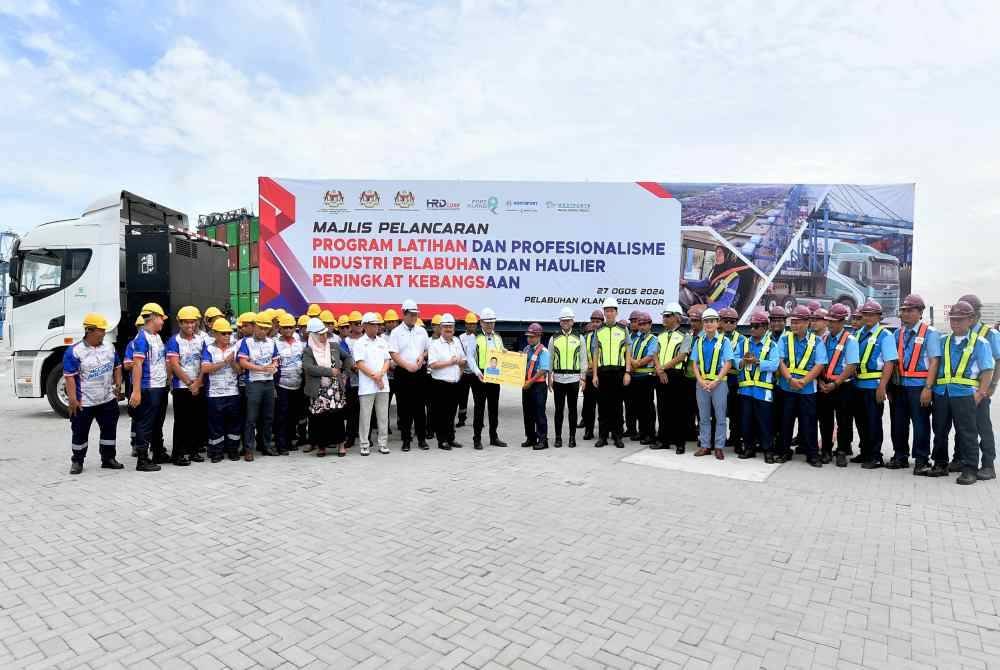 Anthony Loke (tengah) menyerahkan replika lesen kepada wakil peserta selepas pelancaran Program Latihan dan Profesionalisme Industri Pelabuhan dan Haulier Peringkat Kebangsaan di Pelabuhan Klang hari ini. Foto Bernama