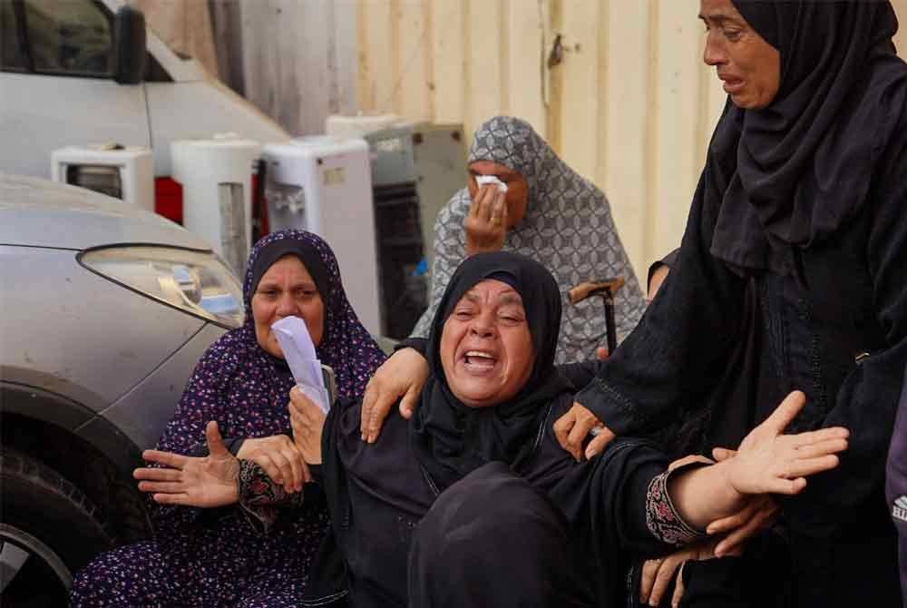 Seorang wanita tidak dapat menahan kesedihan meratapi saudaranya yang terkorban dalam serangan udara rejim Zionis di kediaman mereka di Genting Gaza. - AFP