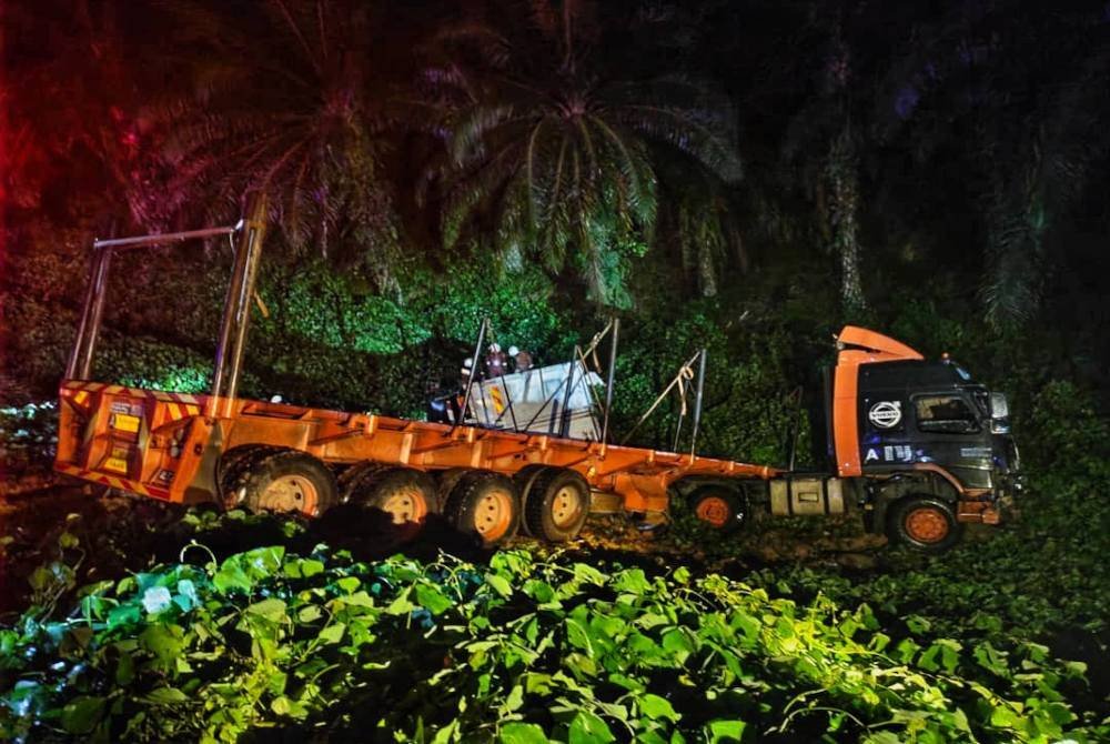 Lori dan treler yang turut terbabas masuk ke dalam gaung akibat kemalangan tersebut di jalan utama Bukit Damar dekat Lanchang pada Selasa. Foto ihsan PDRM 