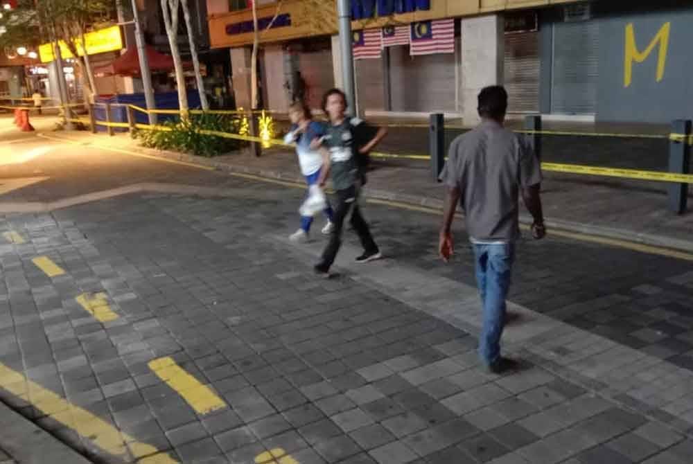 Beberapa individu dilihat masih melintasi laluan yang ditutup dengan pita keselamatan di Jalan Masjid India pada Rabu.