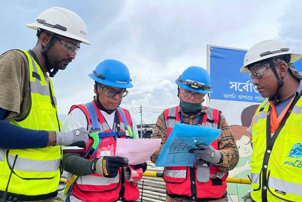 Agus (dua dari kiri) memeriksa permit kerja bagi memastikan kehendak prosedur kerja dipatuhi.