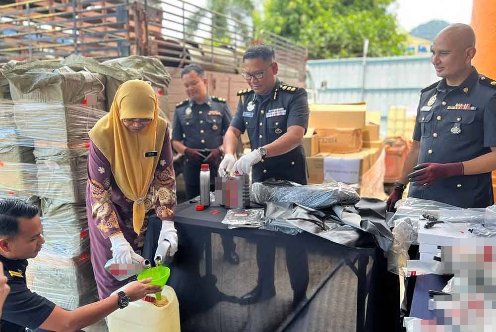 Jezlily (kiri) bersama Ketua Pegawai Penguat kuasa KPDN Pahang, Muhamad Radzi Johari (tengah) menunjukkan antara barang rampasan yang dilupuskan.