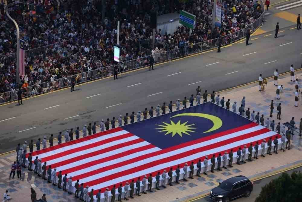 Kontinjen pembawa Jalur Gemilang bersiap sedia pada acara perbarisan dan perarakan sempena sambutan Hari Kebangsaan Ke-67 bertemakan “Malaysia Madani: Jiwa Merdeka” di Dataran Putrajaya pada Sabtu. Foto Bernama