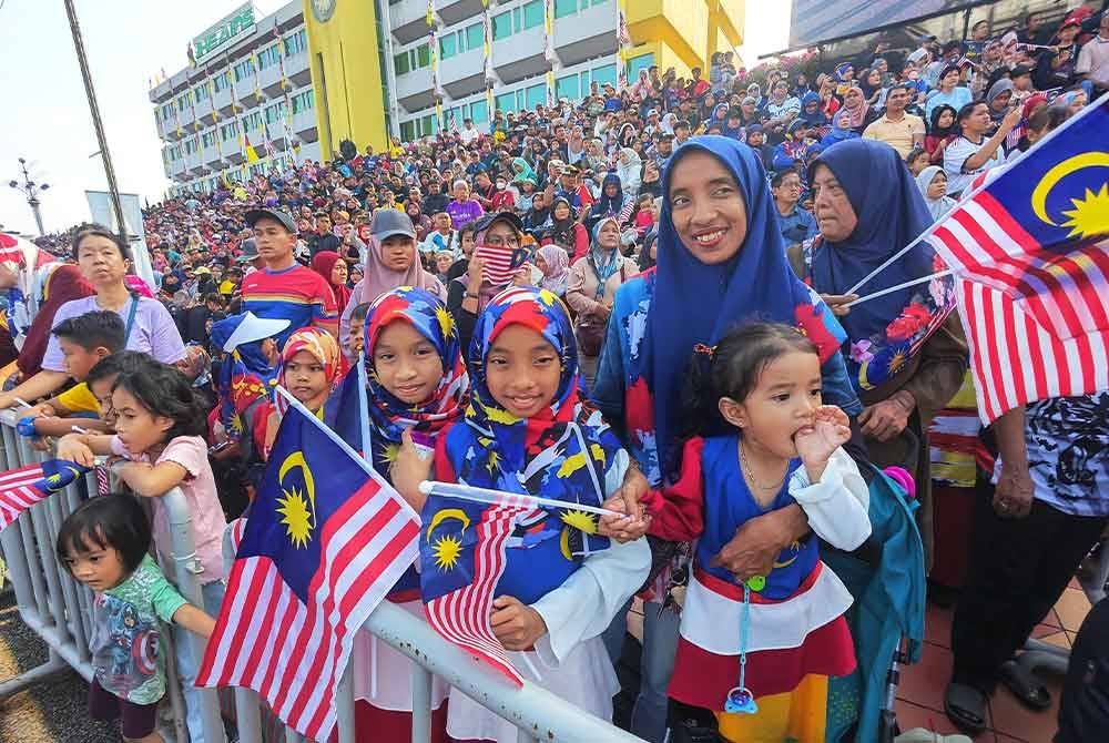 Nurul Ain dan anak-anaknya sedondon memakai pakaian bertemakan Jalur Gemilang bagi meraikan Sambutan Hari Kebangsaan di Padang MBS pada Sabtu.