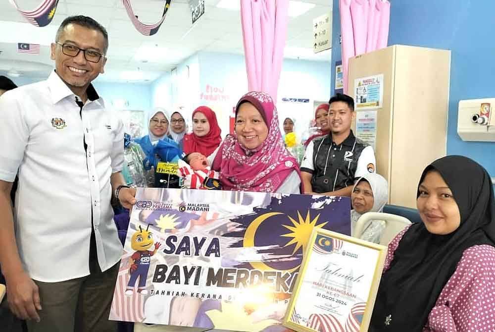 Mohd Zamri (kiri) bersama Kasemani (tengah) menyantuni ibu kepada bayi merdeka sempena program Menyemai Kasih Rakyat (MEKAR) di PRIBA, Hospital Sultanah Nur Zahirah, Kuala Terengganu pada Sabtu.