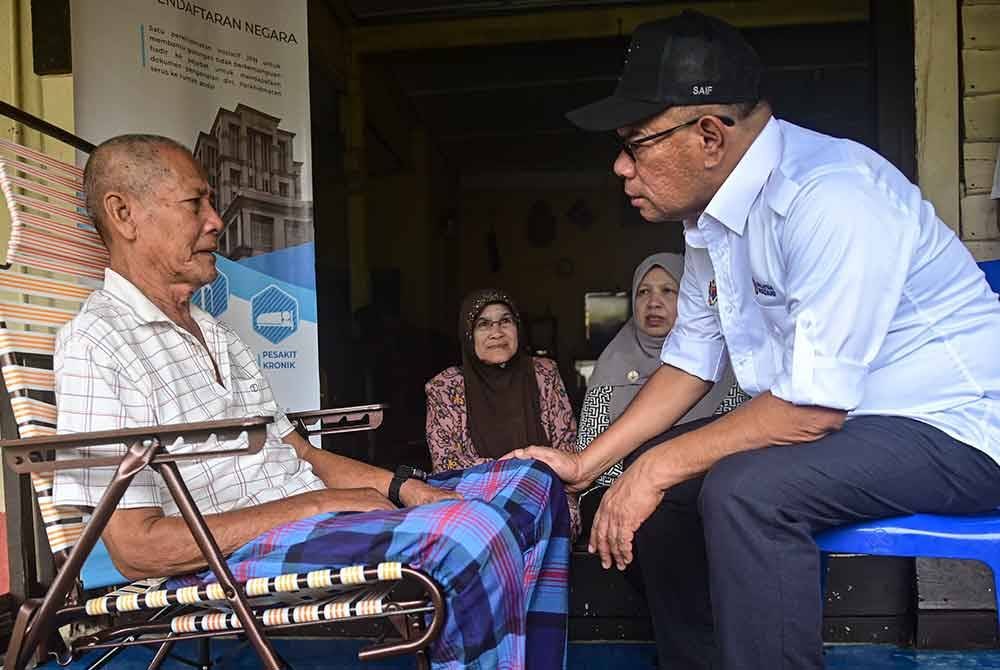 Saifuddin Nasution (kanan) menziarahi warga emas, Rajab Che Embong, 70 (kiri) pada Program Menyemai Kasih Rakyat (MEKAR) Penyerahan Dokumen Pengenalan Diri di Kampung Baru Pulau Redang, pada Sabtu. Foto Bernama