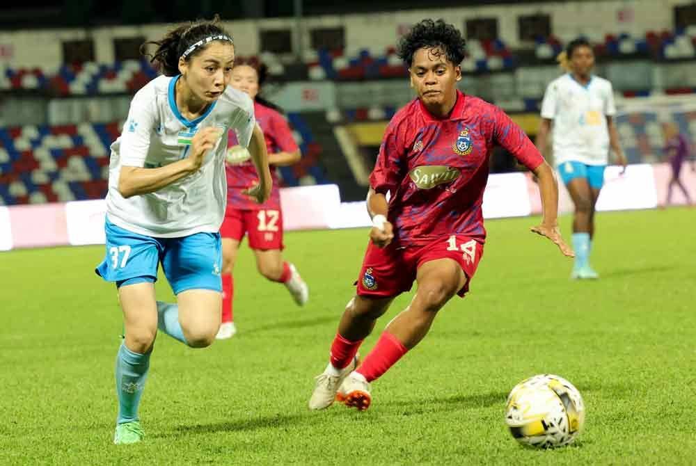 Pemain Sabah FA, Malaysia, mengawal ketat pergerakan pemain PFC Nasaf dari Uzbekistan Burkhonova Maliki (kiri) pada saingan Liga Champions Wanita Asia (AFC) di Stadium Likas, pada malam Sabtu. Foto Bernama