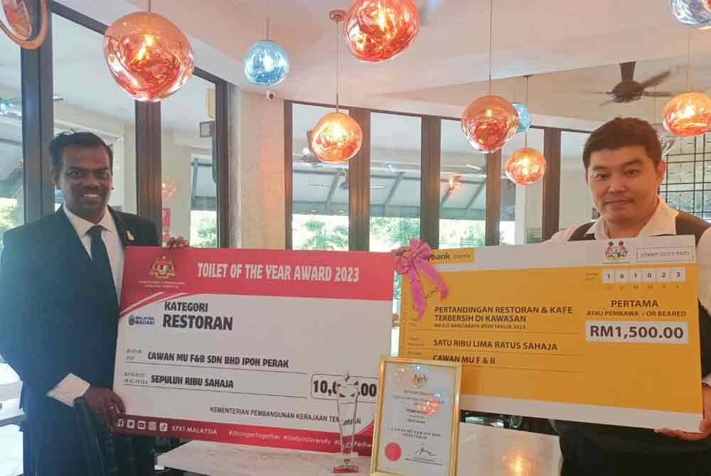 Christopher (kanan) bersama Pengurus Pembangunan Perniagaan restoran Cawan Mu, Sri Lingaswaran menunjukkan hadiah yang dimenangi dalam Anugerah TOTYA 2023.