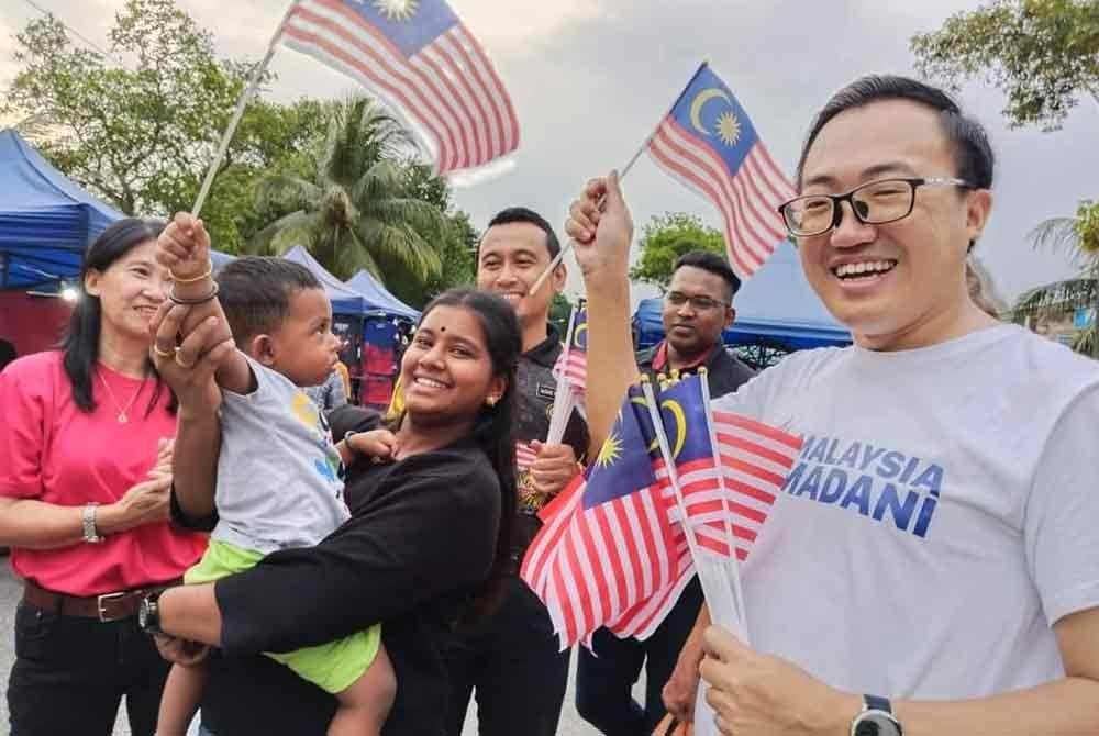 Bor Yang (kanan) ketika mengedarkan Jalur Gemilang sempena Bulan Kemerdekaan baru-baru ini.