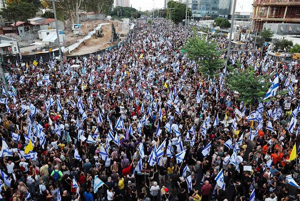 Lautan manusia membanjiri jalan utama di Tel Aviv sebagai menterjemahkan rasa marah rakyat Israel pada cara Perdana Menteri Benjamin Netanyahu tangani krisis tebusan. - Foto AFP