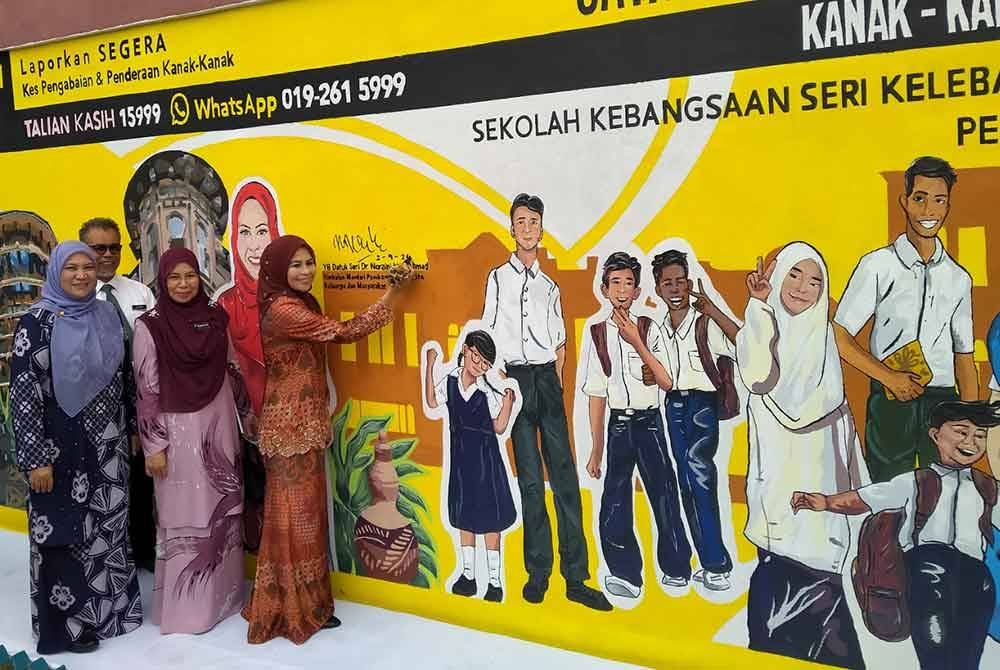 Noraini (tiga dari kiri) menandatangani mural selepas menyempurnakan Program Advokasi Perlindungan Kanak-Kanak: Kasih Kanak-Kanak Peringkat Negeri Perak di Sekolah Kebangsaan Seri Kelebang, Chemor di sini, pada Isnin.