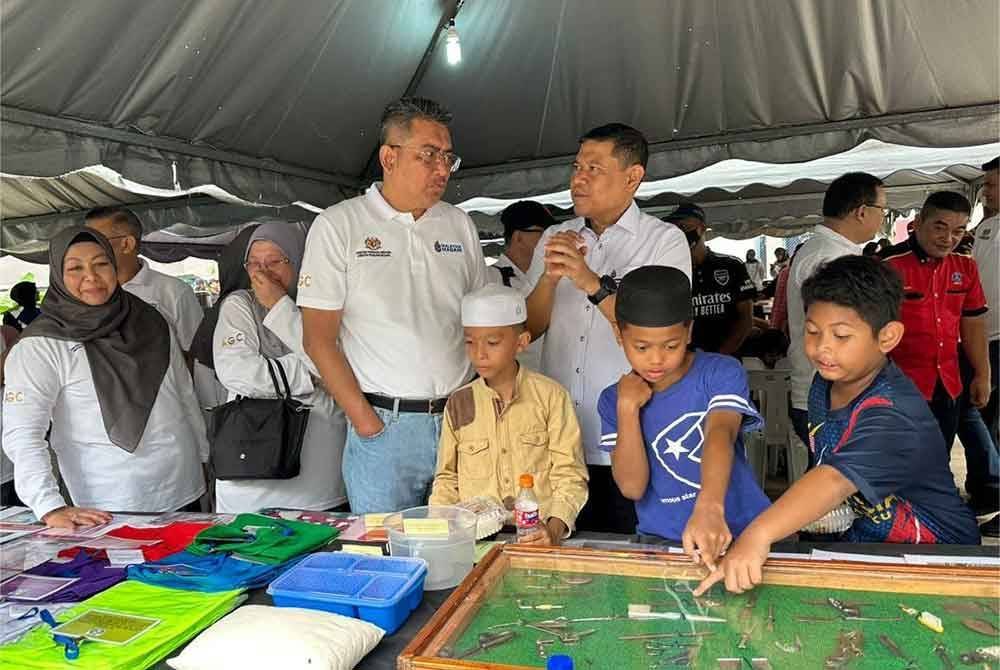 Ahmad Terrirudin (dua dari kanan) ketika melawat ruang pameran sambil beramah mesra dengan penduduk setempat.