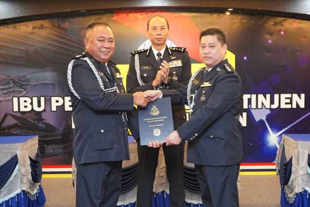 Maslan (kiri) menyerah dokumen serah terima tugas kepada pemangku Ketua Polis Daerah Jelebu Goh dalam satu majlis di lPK Negeri Sembilan disaksikan Ahmad Dzaffir (tengah). Foto PDRM