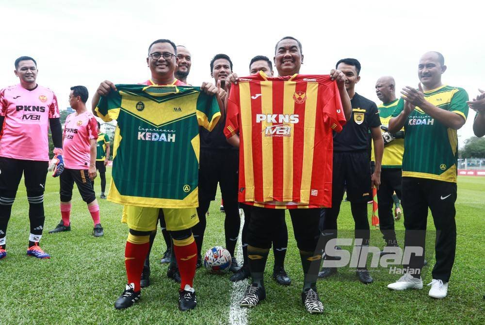 Muhammad Sanusi (kiri) bersama Amirudin (kanan) bertukar-tukar jersi sebelum memulakan perlawanan. Foto Sinar Harian-ASRIL ASWANDI SHUKOR