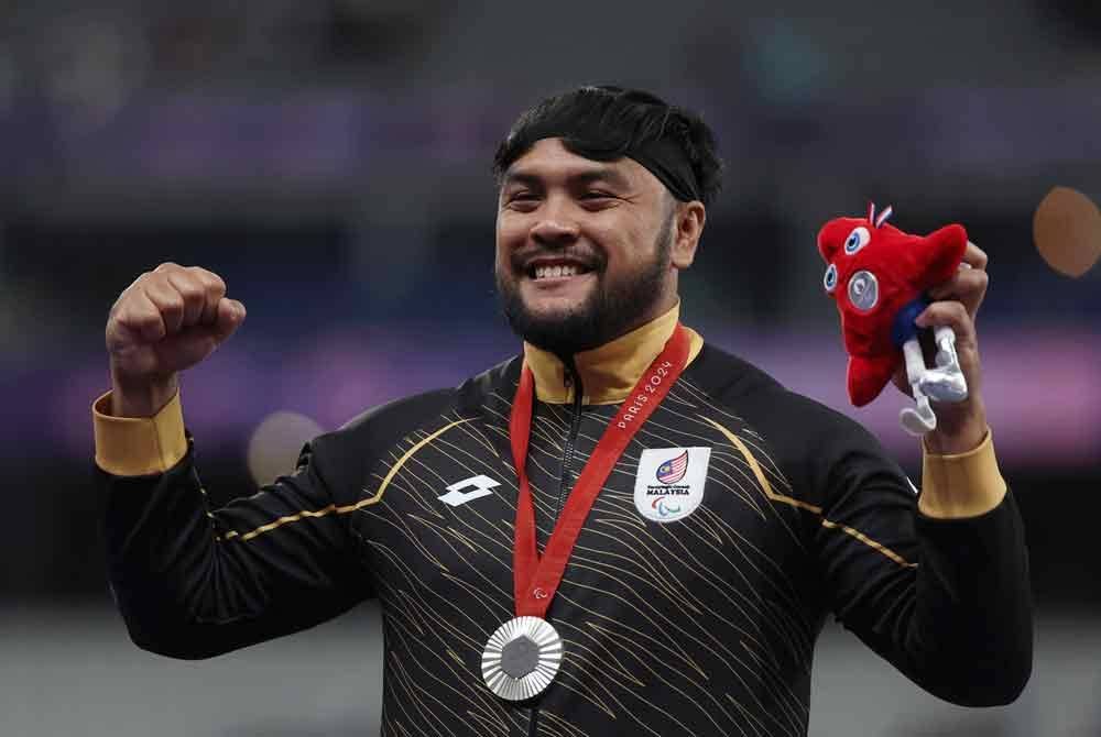 Ziyad tersenyum selepas dikalungkan pingat perak dalam acara lontar peluru lelaki F20 (kecacatan intelektual) Paralimpik Paris 2024 di Stade de France. Foto: Bernama