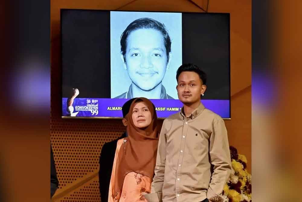 Eeliani (kiri) dan anaknya Mohamad Izzul mewakili Allahyarham Muhammad Hassif Hamim untuk menerima skrol sempena Istiadat Konvokesyen UiTM ke-99.