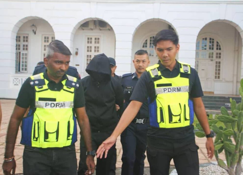 Pegawai kanan polis, DSP Mohd Nazri Abdul Razak (tengah) ketika dibawa ke Mahkamah Tinggi Ipoh pada Khamis. 