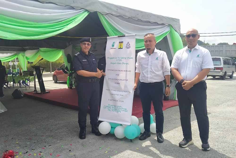 Zulkafli (kiri) ketika menyempurnakan gimik Program GTSP Wilayah Utara (Perak) Petronas Dagangan Berhad dan Polis Diraja Malaysia di Stesen Petronas Kampung Kepayang, Simpang Pulai di Ipoh pada Khamis.