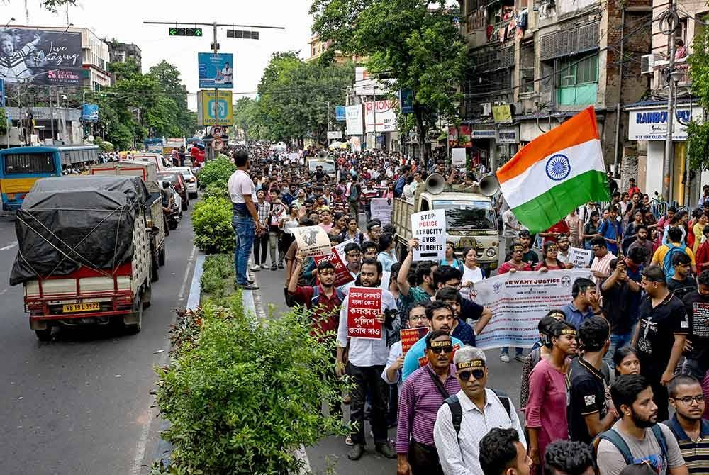 Kumpulan doktor junior berarak sambil mengibarkan bendera kebangsaan ketika menyertai demonstrasi di Kolkata.