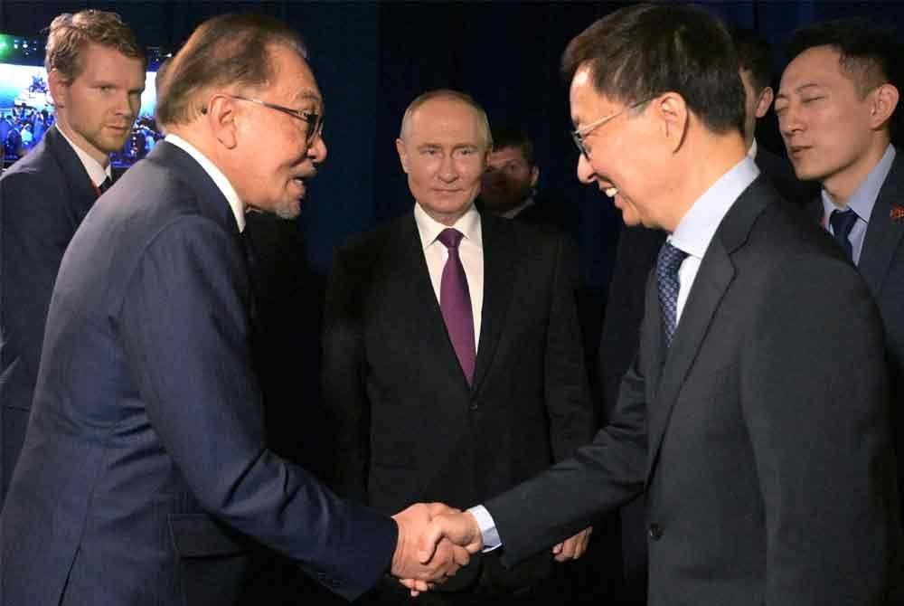 Vladimir Putin (tengah) menyaksikan Anwar (dua dari kiri) bersalam dengan Naib Presiden China Han Zheng (dua dari kanan) selepas Forum Ekonomi Timur di Vladivostok pada Khamis. Foto Sputnik/AFP