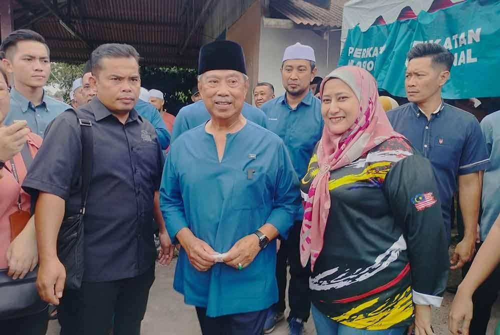 Muhyiddin bergambar dengan tetamu yang menghadiri majlis Kenduri Rakyat di Kampung Bentong, Kluang pada Jumaat.