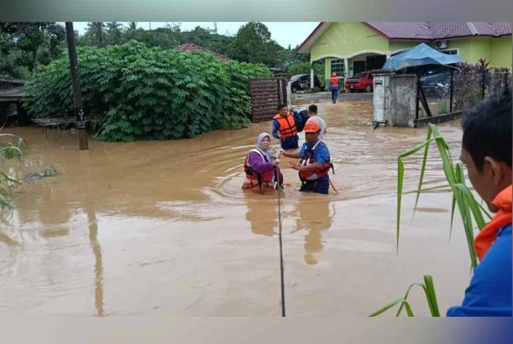 Anggota APM membantu memindahkan mangsa di sebuah kampung di mukim Kupang, pada Sabtu.