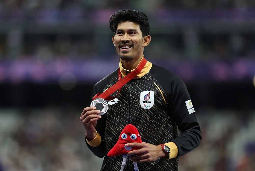 Jaguh olahraga para negara, Datuk Abdul Latif Romly memperagakan pingat perak yang dimenangi dalam acara lompat jauh lelaki T20 (kecacatan intelektual) pada Sukan Paralimpik Paris 2024 di Stade de France pada Sabtu.