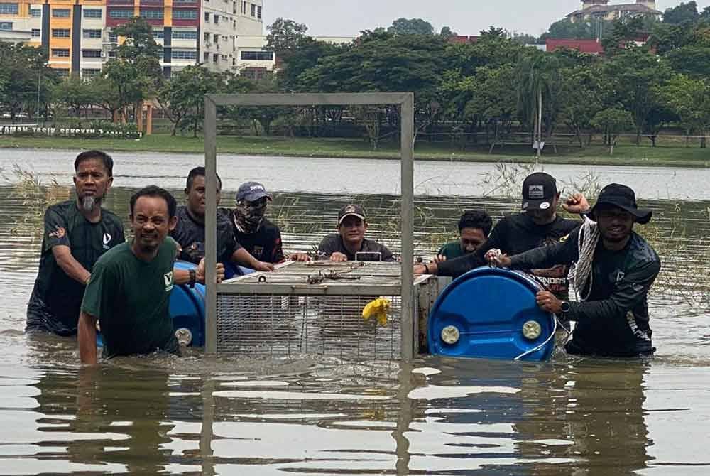 Anggota Perhilitan Selangor mengeluarkan perangkap yang dipasang di Taman Tasik Shah Alam Seksyen 7 dekat sini.