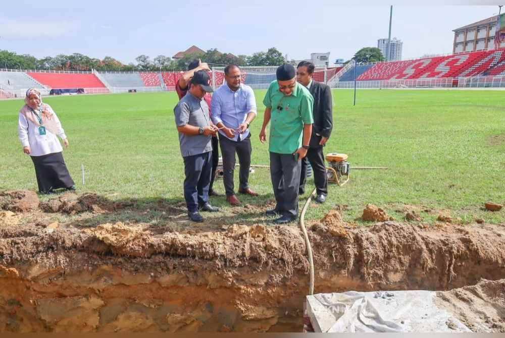 Zamakhshari (kanan) yang melihat kerja-kerja menambah baik sistem perparitan SSMIV dijalankan. Foto ihsan UPKN