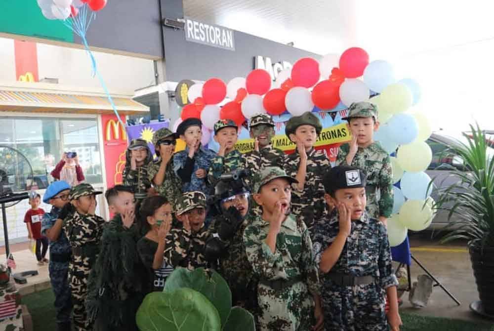 Kanak-kanak cilik mengenakan pakaian tentera membuat persembahan sempena Sambutan Hari Malaysia di Stesen Minyak Petronas NKVE KM 15.3 Arah Damansara, pada Selasa.