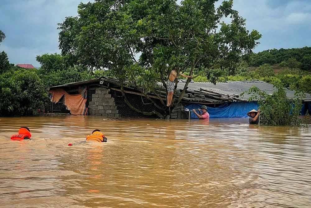 Pasukan penyelamat membantu orang ramai berpindah dari kawasan banjir di wilayah Bac Ninh di utara Vietnam - Foto: Xinhua