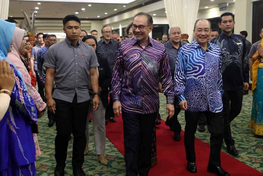 Anwar diiringi Hajiji ketika tiba di majlis makan malam kerajaan negeri Sabah di Magellan Sutera Harbour Kota Kinabalu, pada Rabu. Foto Bernama