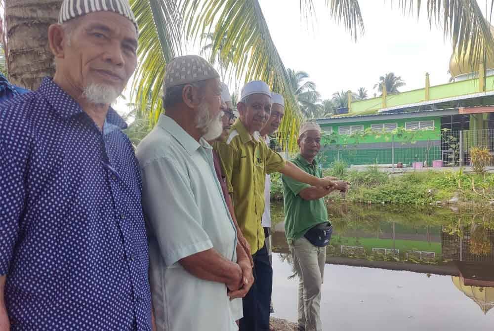 Jemaah masjid menunjukkan keadaan hakisan yang berlaku di Masjid Ubudiah Kampung Simpang 4 Bagan Nakhoda Omar di sini pada Khamis.