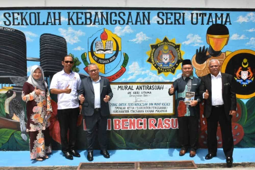 (Tiga dari kiri) Norazlan menandatangani mural antirasuah yang disediakan oleh pihak sekolah.