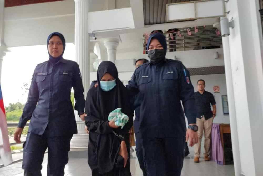 Nor Afifah (tengah) ketika dibawa keluar dari Mahkamah Majistret pada Jumaat