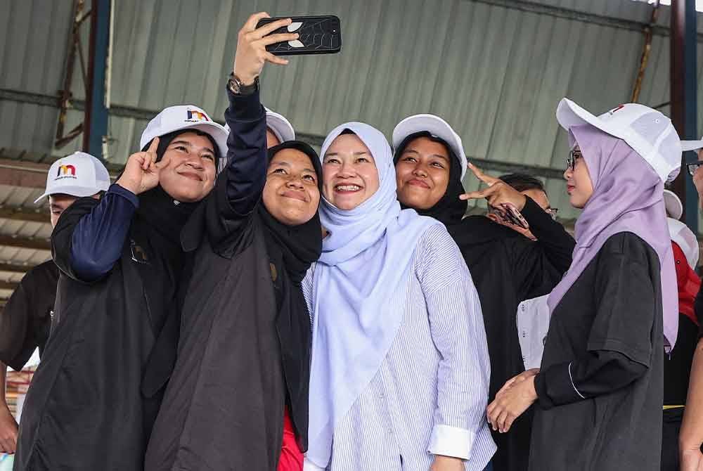 Fadhlina (dua dari kanan) sempat berswafoto bersama sukarelawan Inspirasi Malaysia pada Program Inspirasi Malaysia di Sekolah Menengah Kebangsaan Tengku Aris Bendahara pada Jumaat. Foto Bernama