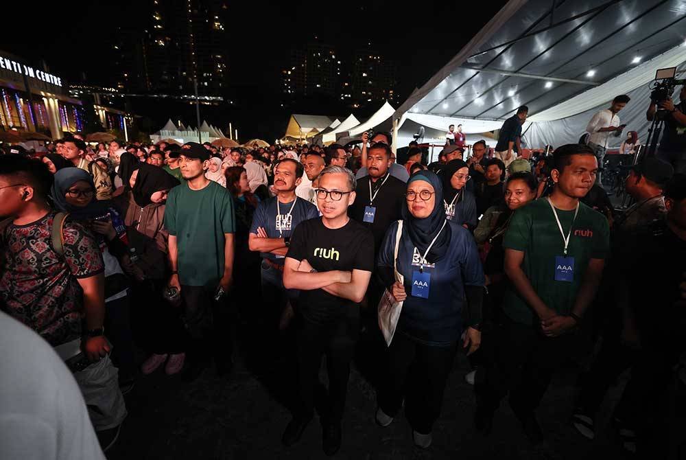 Menteri Komunikasi Fahmi Fadzil (tengah) meluangkan masa menyaksikan konsert sewaktu mengunjungi Riuh Bah! di Pusat Konvensyen Antarabangsa Sabah malam ini. Foto Bernama