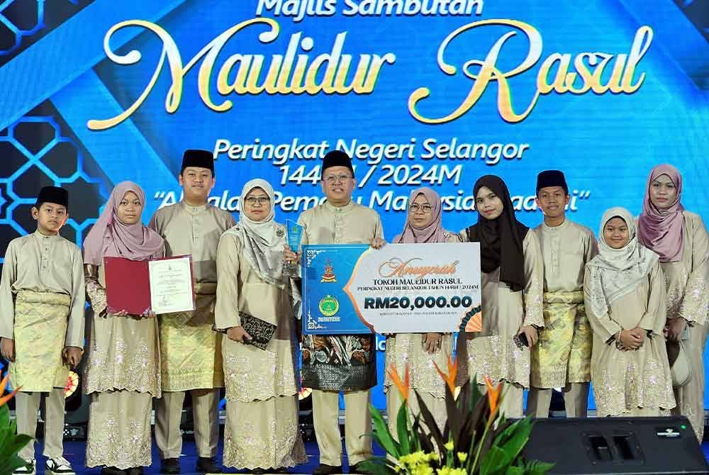 Penerima anugerah Tokoh Maulidur Rasul Tahun 1446H Profesor Madya Dr Abd Rauf Hassan (lima kiri) bergambar bersama keluarga ketika Majlis Sambutan Maulidur Rasul Peringkat Negeri Selangor Tahun 1446H di Dewan Syarahan dan Muzakarah Masjid Sultan Salahuddin Abdul Aziz Shah, Shah Alam hari ini. - Foto: Bernama