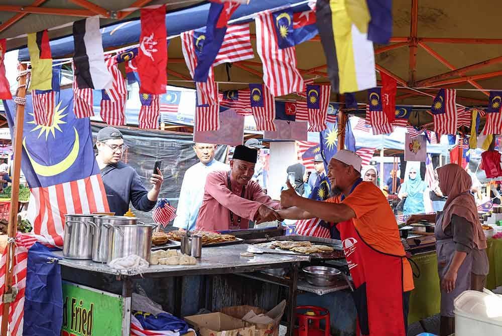 Calon PN, Mohamad Haizan Jaafar melakukan walkabout menyantuni peniaga di Pasar Tani Kampung Melayu sempena kempen PRK Mahkota hari ini - Foto: Bernama