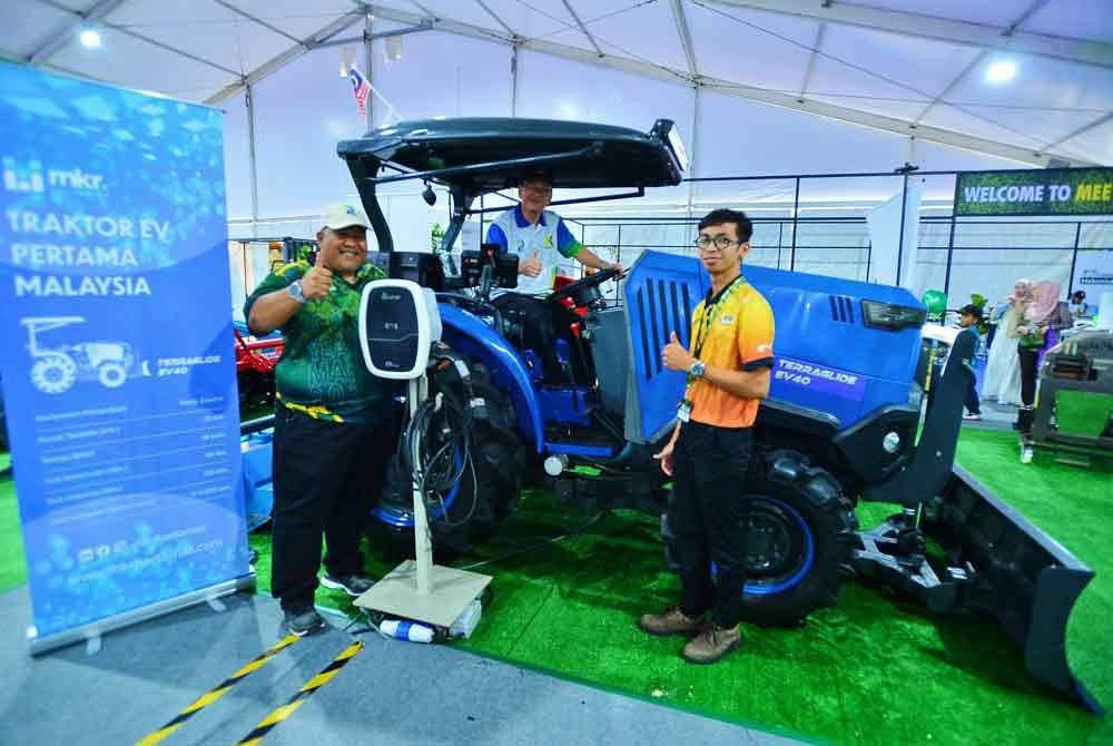 Mohd Fauzi (tengah) yang diiringi Pengarah Bahagian Kejuruteraan LPP, Zaipudin Mohamad (kiri) cuba mengendalikan traktor elektrik yang dipamerkan di Laman Mekanisasi sempena MAHA 2024 pada Isnin.