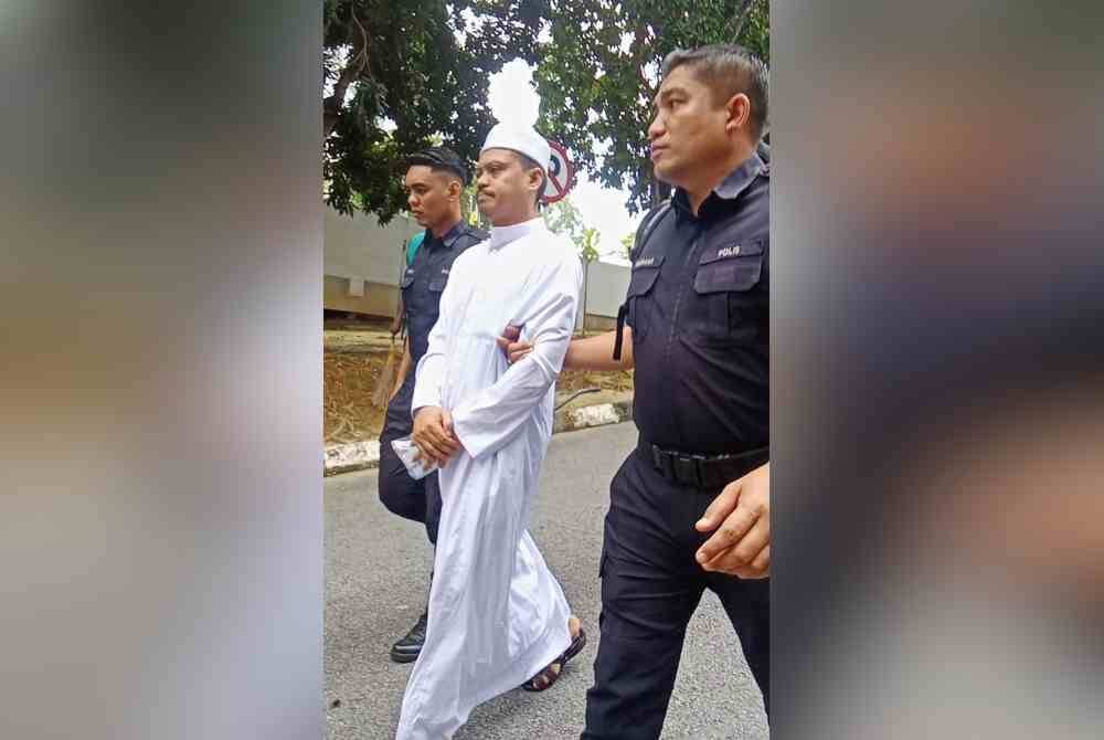 Mohd Hafidz Eshak diiringi anggota polis ketika tiba di Mahkamah Sesyen Seremban pada Rabu atas tiga pertuduhan melakukan amang seksual fizikal terhadap seorang remaja perempuan.