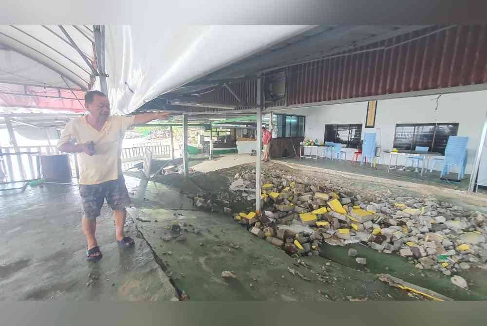 Seng Kok menunjukkan struktur lantai kedai yang runtuh berikutan ombak kuat sejak pagi Selasa.