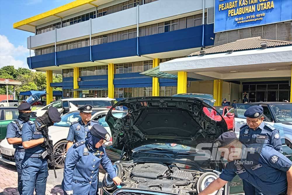 Norlela (depan, dua dari kiri) meneliti sebuah kenderaan import mewah yang dirampas JKDM dalam satu serbuan Ops Longkai 2024 di Pelabuhan Utara dan Pelabuhan Barat, Klang, Selangor, baru-baru ini.