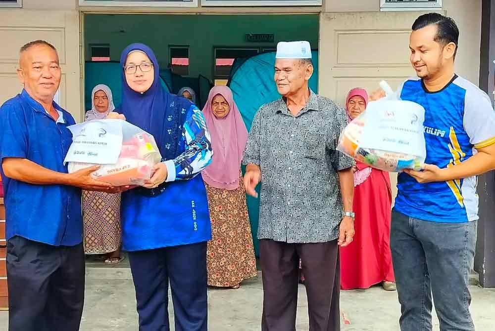 Nor Rahila (tiga dari kanan) menyampaikan sumbangan pek makanan kepada mangsa banjir di PPS Lubuk Batu.